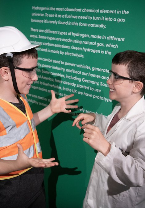 two boys smile and chat in the Steam to Green space