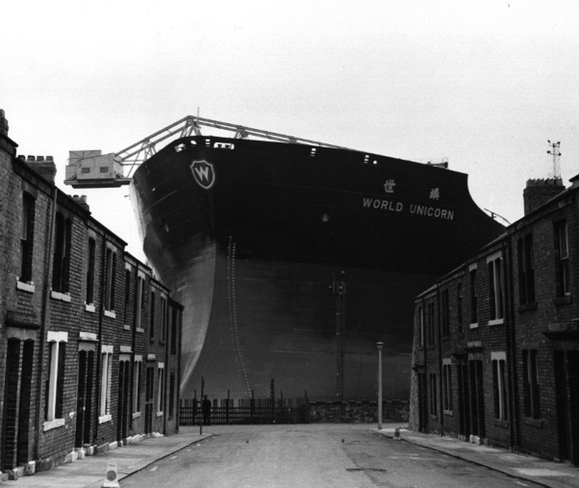 a massive ship towering over rows of terraced houses