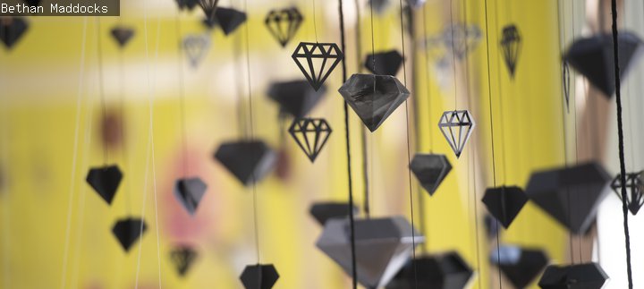 Black diamonds of paper and card hanging by threads