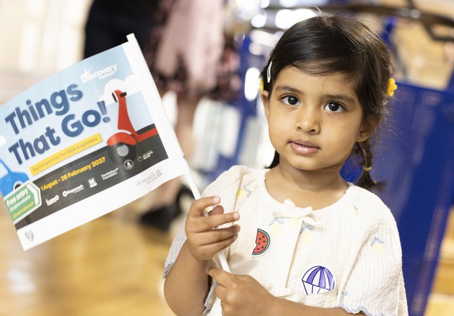 litle girl wavs flag in museum
