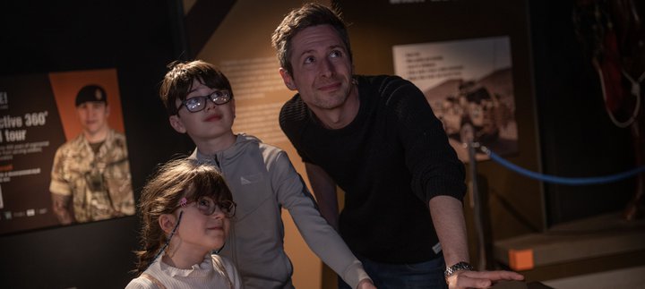 a family group, dad and son and daughter looking up