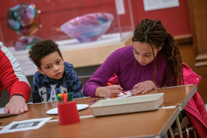 A photograph of a boy and girl doing crafts together.