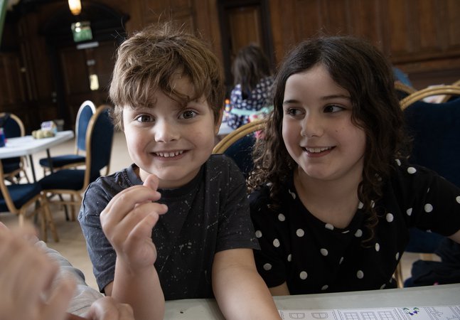 Two children grin in the Great Hall