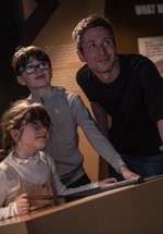 a family group, dad and son and daughter looking up