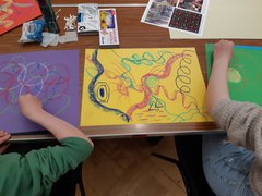 Two young people creating art using pastels