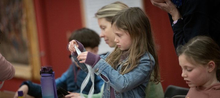 Adults and children taking part in a craft activity together.