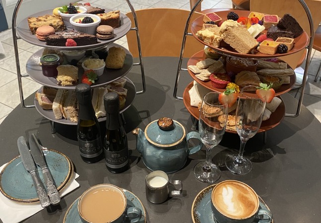 A photograph of three tiered afternoon tea with drinks