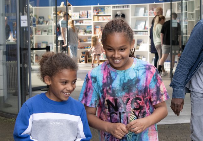 two girls giggle at entrance to museum