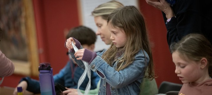 Adults and children taking part in a craft activity together.