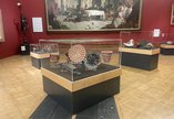 A photograph of three display cases with ceramics inside.