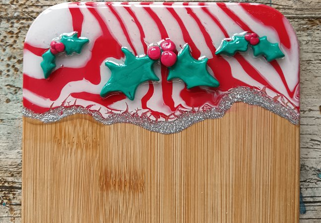 A photograph of a serving board with holly decorations.