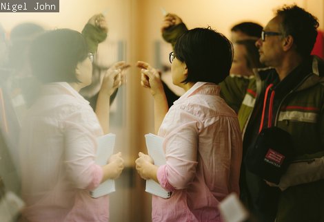 Participants in the refugees and asylum seekers tour guide project looking at museum objects in a class case