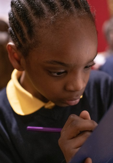 Child writing on clipboard