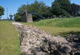 Part of original section of Hadrian's Wall with Segedunum's viewing tower in the background