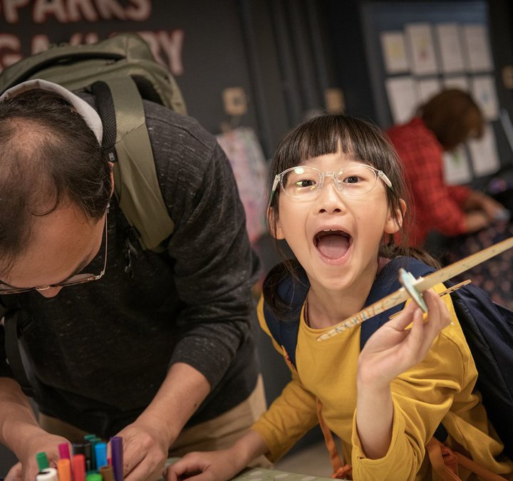 A smiling girl and a man enjoying an activity. 