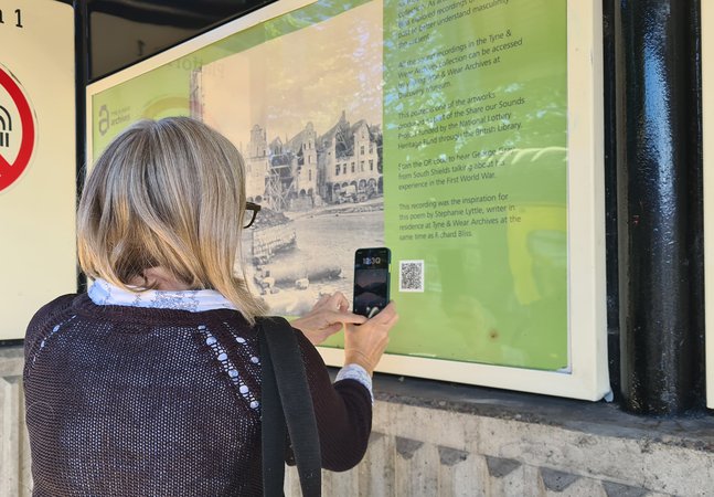 Image of Metro station poste with women looking on in interest with phone