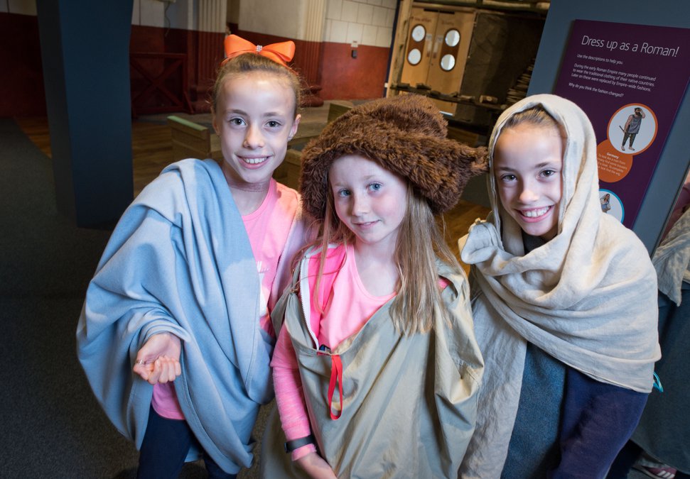 Three girls in gallery dressed in roman robes