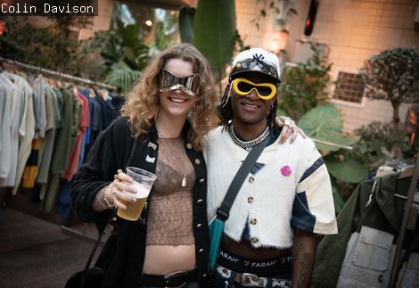 Two visitors wearing sunglasses, smiling for a photograph in The Garden Room at The Biscuit Factory
