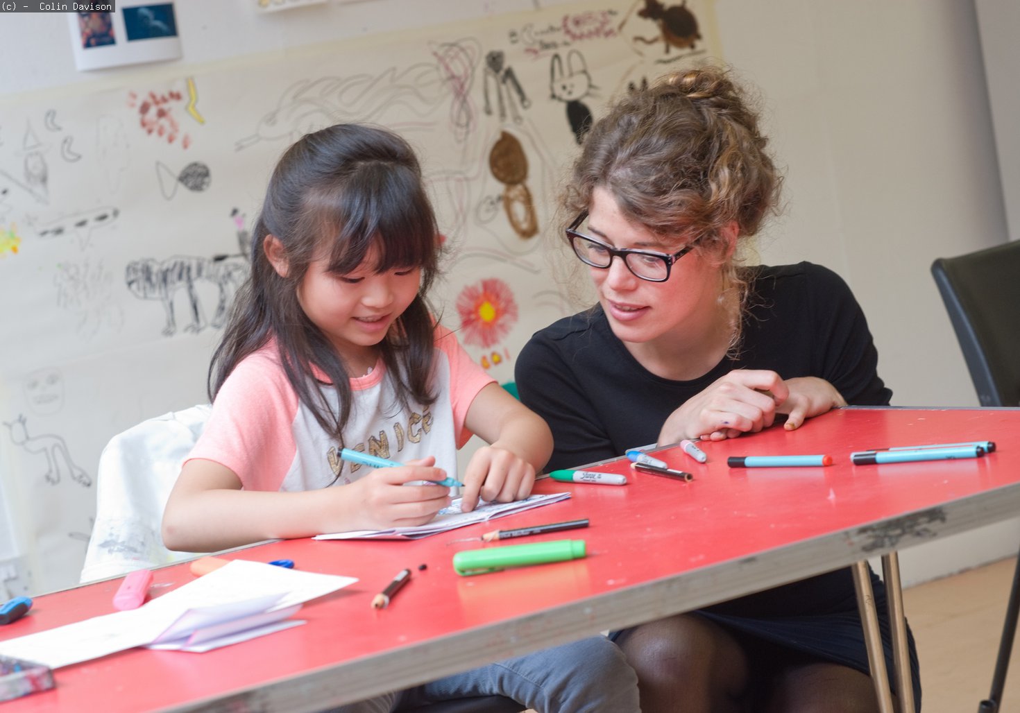 Young girl talking to an art educator