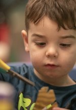 A young child is cutting some paper. 