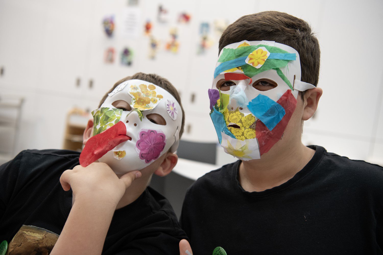 Two children wear collage masks Two children wear collage masks