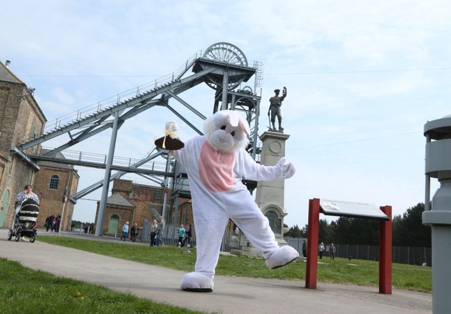 Person dressed in bunny costume against a backdrop of colliery buildings 