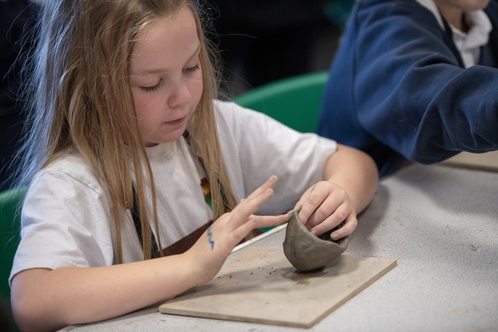 Young girl handling some pottery