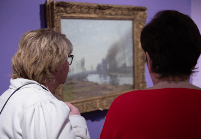 Two people viewing the Monet artwork