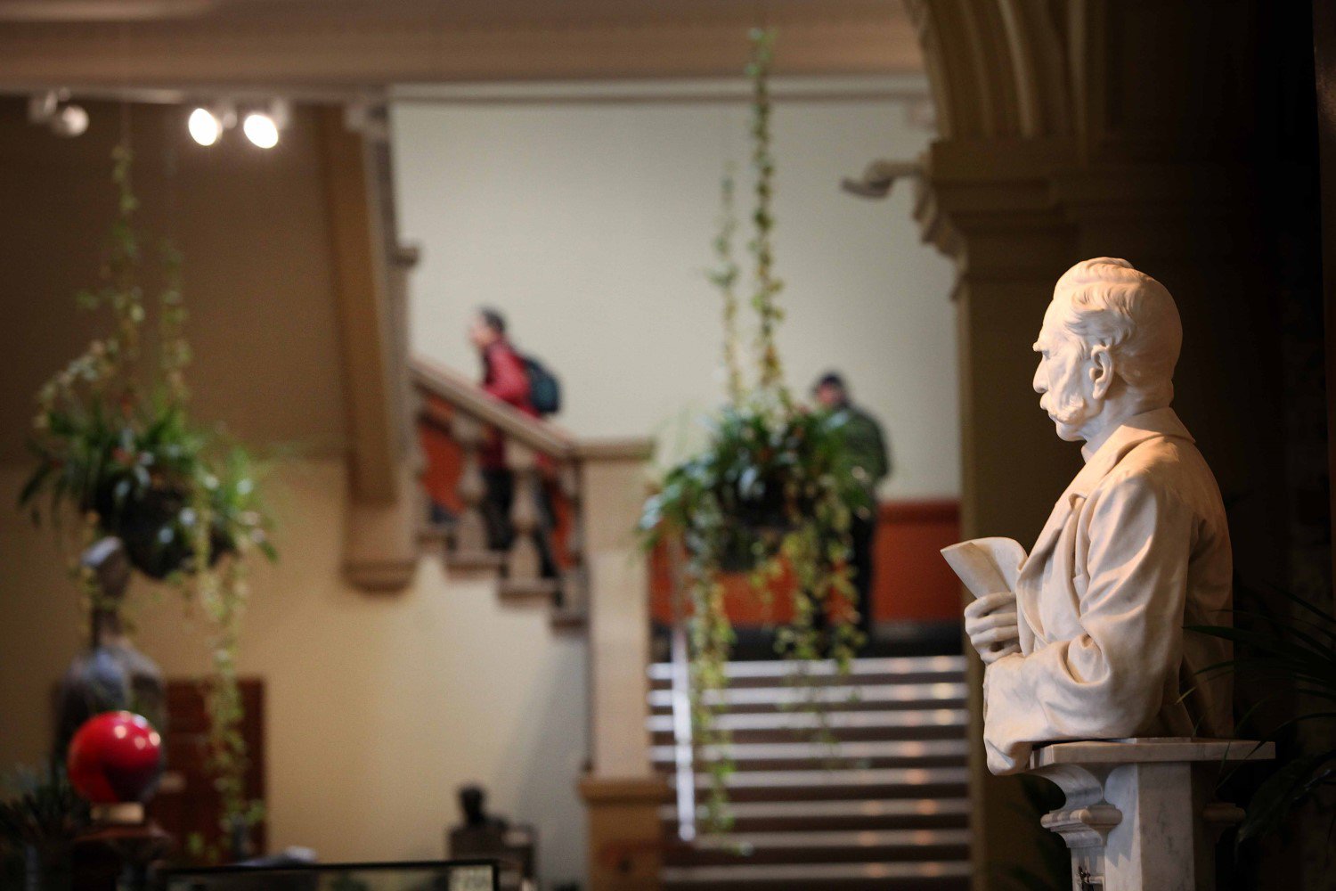 In the foreground is a bust of Alexander Laing. In the background are visitors climbing the stairs In the foreground is a bust of Alexander Laing. In the background are visitors climbing the stairs