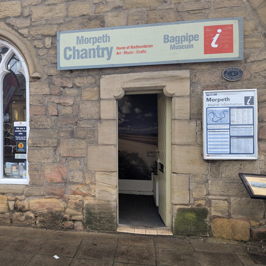 Doorway in a very old, stone building. Sign above says 'Morpeth Chantry'.