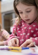 A young child is crafting at a table