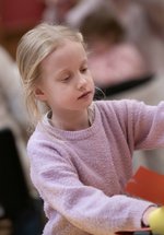 A girl with long blonde hair taking part in a craft activity