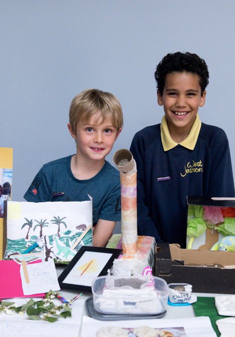 Two schoolchildren standing at a stall with their science project