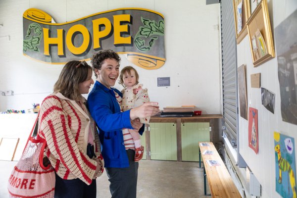 A family smiling and pointing at artworks in the creative space at Woodhorn A family smiling and pointing at artworks in the creative space at Woodhorn