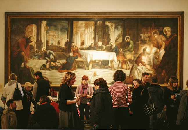 A crowd gathered in front of a large painting.