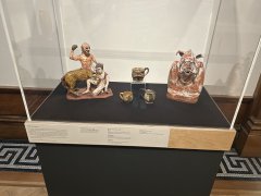 A glass display cases with a selection of ceramic objects. The label for the cases reads 'Myths and Legends' in black text on a cream background.