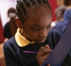 Child writing on clipboard