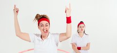 Two women dressed as PR teachers play with hula hoops