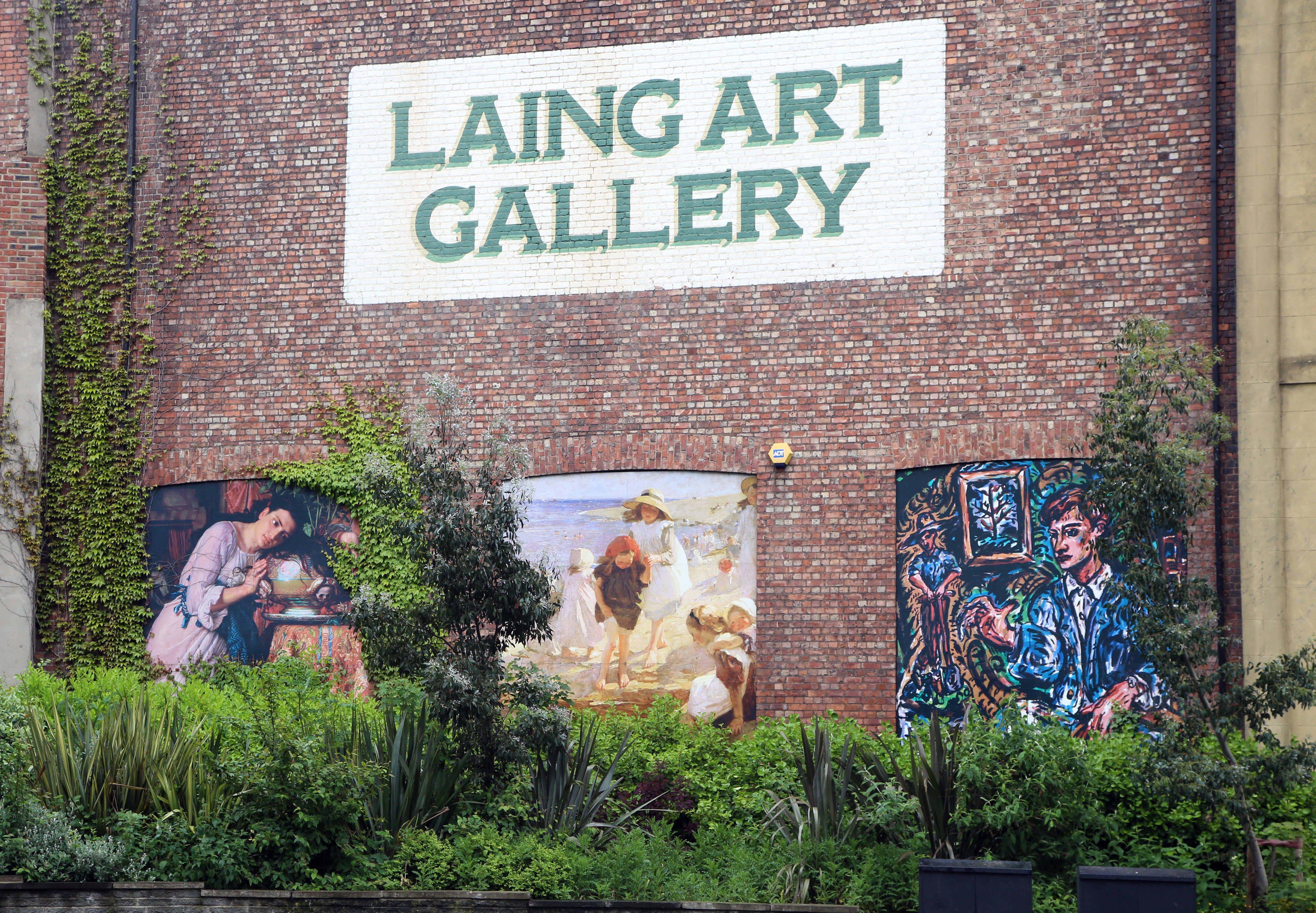 A close up exterior view of the Laing Art Gallery. The brickwork shows three artworks