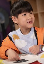 cheeky smiling boy doing craft