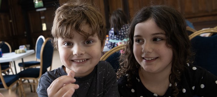 Two children grin in the Great Hall