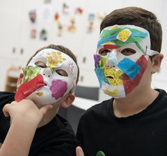 Two children are making masks.