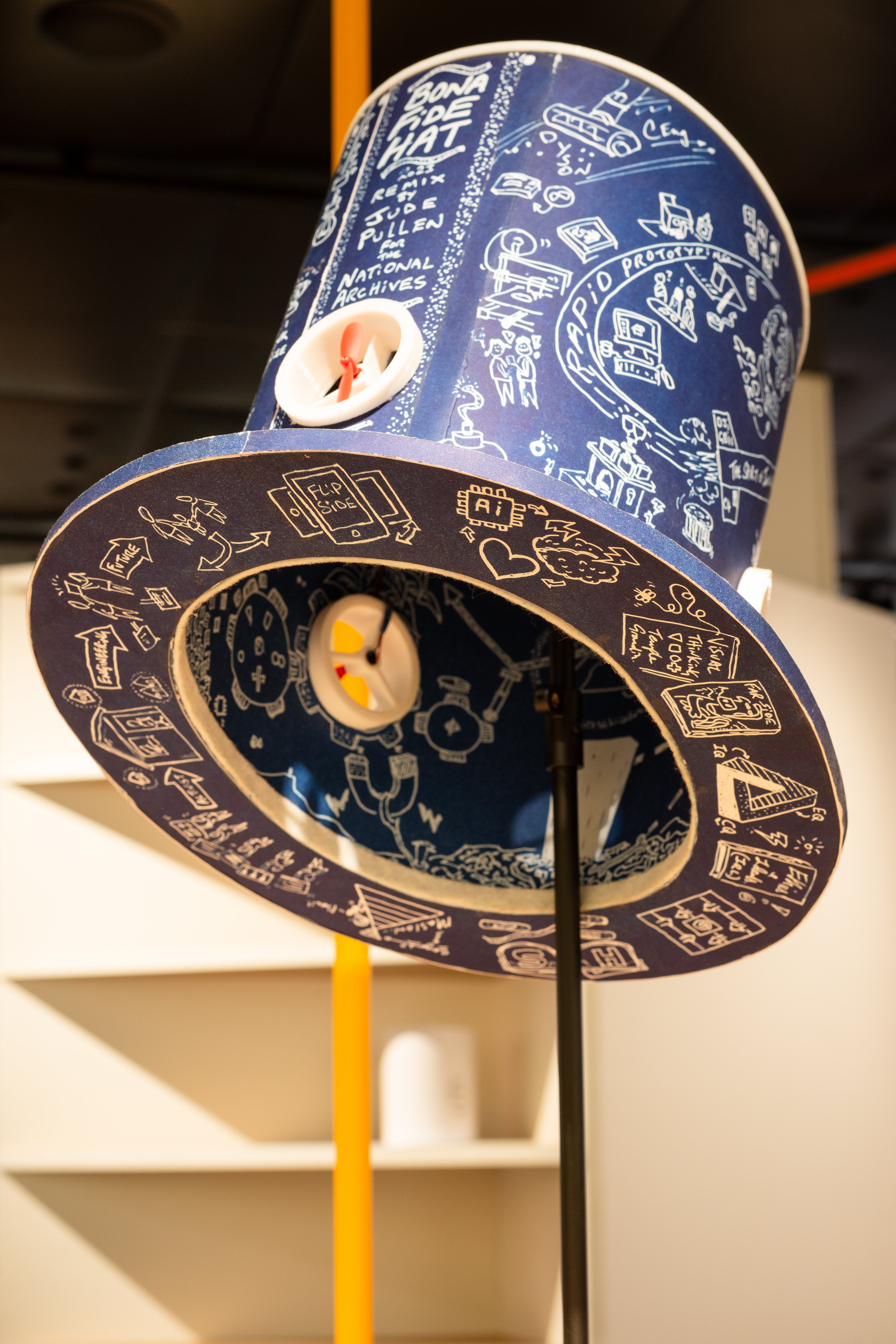 A prototype invention in the shape of a blue top hat. It has white writing on it and fans incorporated.