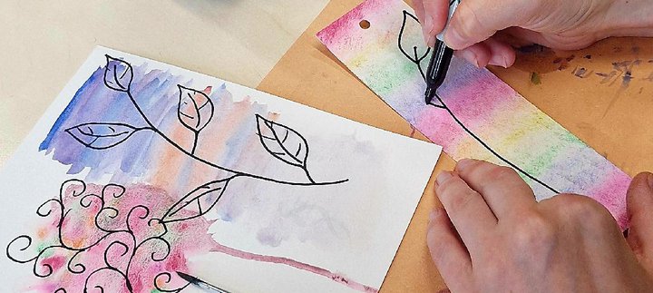 A hand watercolour painting a bookmark.