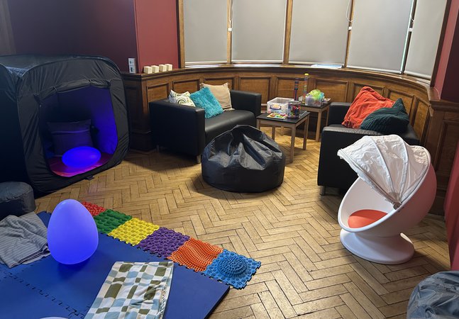 A room with comfy seating and a variety of toys.
