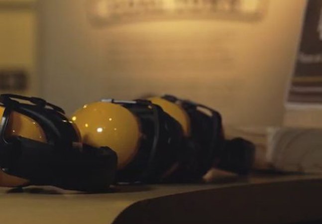 3 pairs of headphones lying side down on a table next to a sign 
