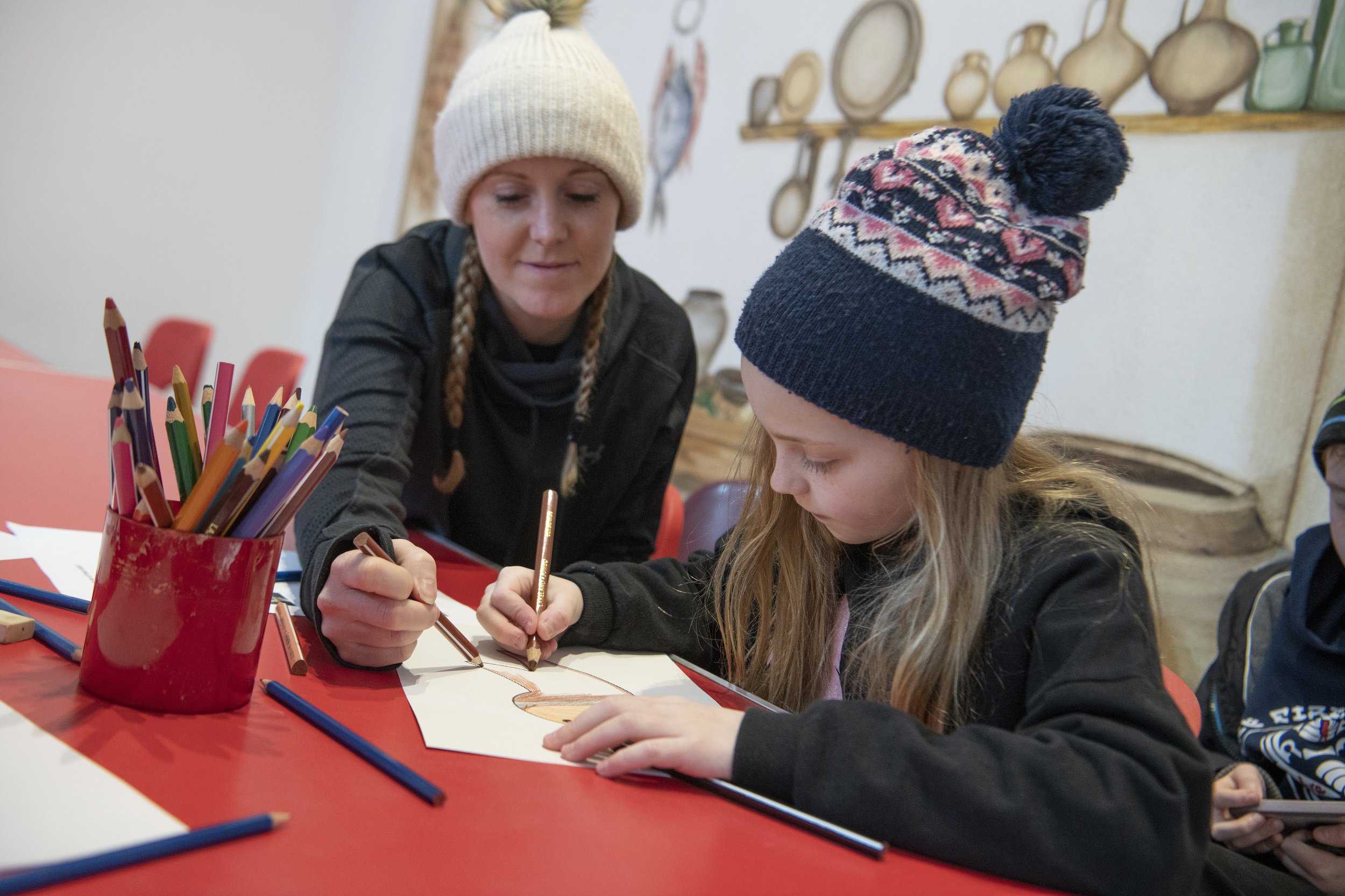 A woman and child sit at a table, drawing A woman and child sit at a table, drawing