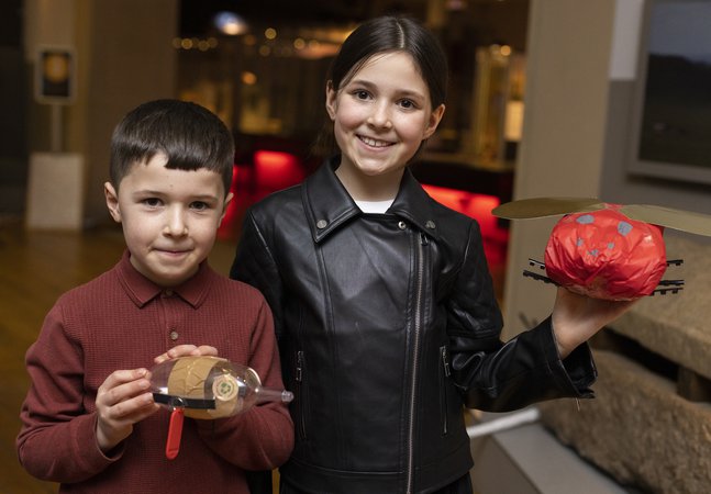 Two children holding crafty creatures