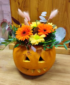 A floral arrangement inside a carved pumpkin