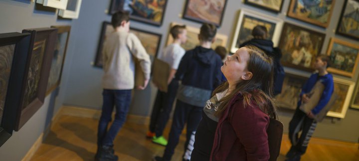A child looks at a display of paintings in the Ashington Group Gallery at Woodhorn Museum